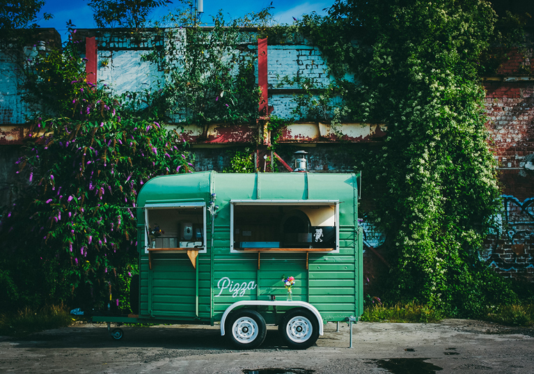 Green Dough Man's Land horsebox in front of leafy, floral background